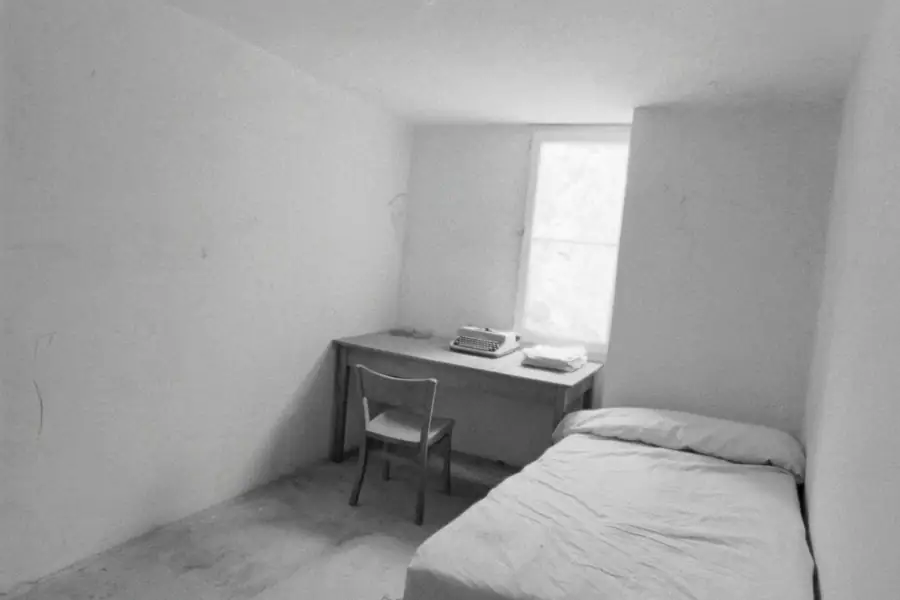 Une chambre simple, bureau contre la fenêtre